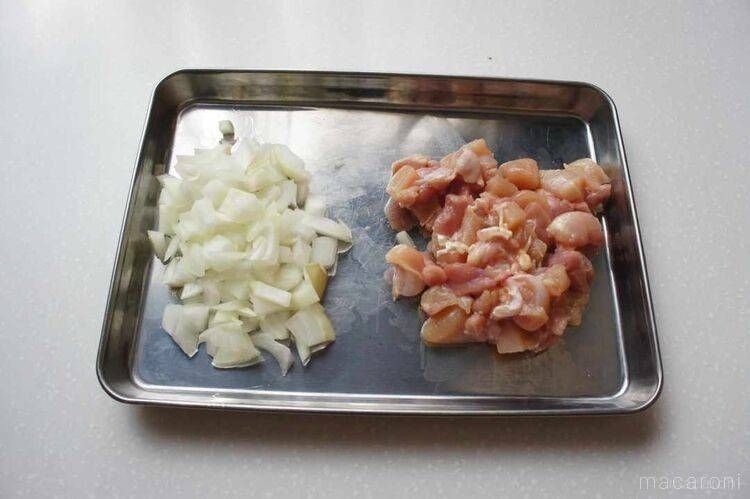 カットした鶏もも肉と玉ねぎをステンレス製のバットに置いた様子