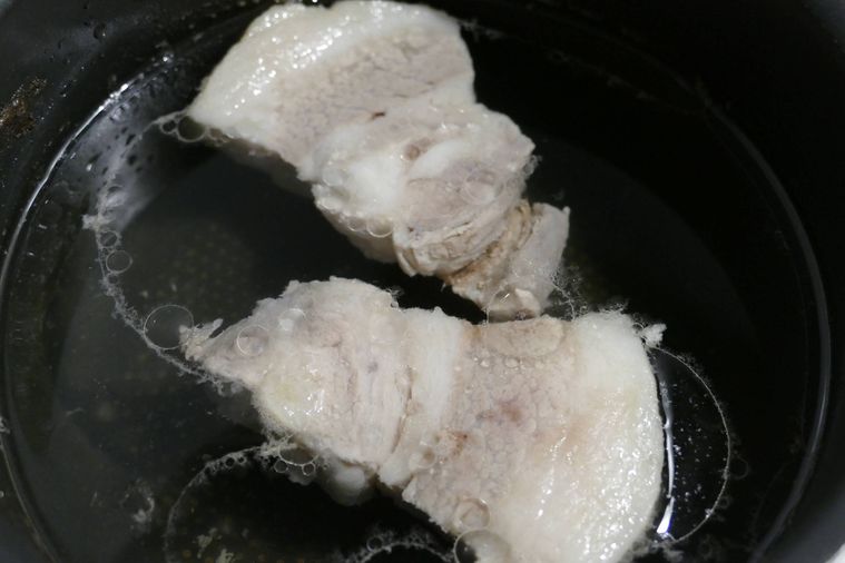 豚ロース肉をゆで汁に浸したまま冷ます様子