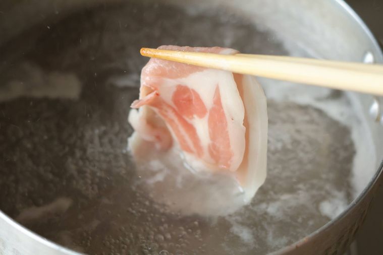 お湯で豚肉をゆでている