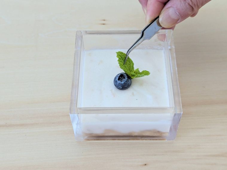 フルーチェヨーグルトケーキにミントとブルーベリーをトッピングしている様子