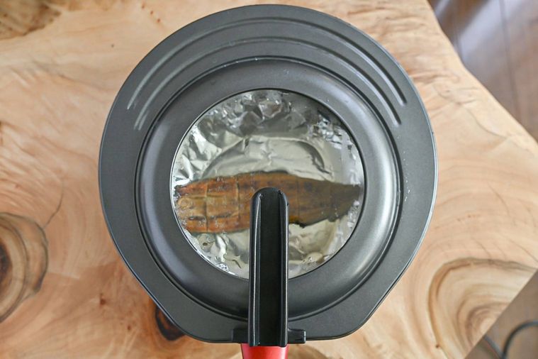 蓋をしたうなぎの蒲焼が入ったフライパン