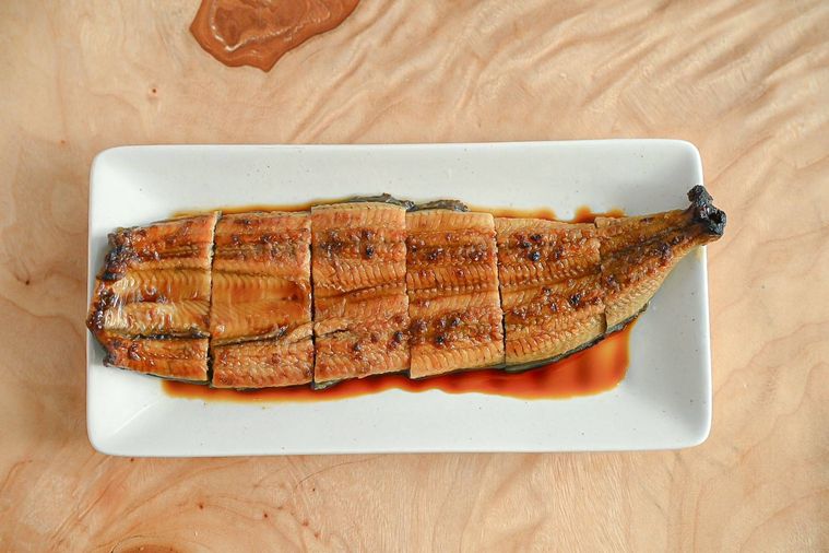 皿にのったフライパンで蒸し焼きにしたうなぎの蒲焼