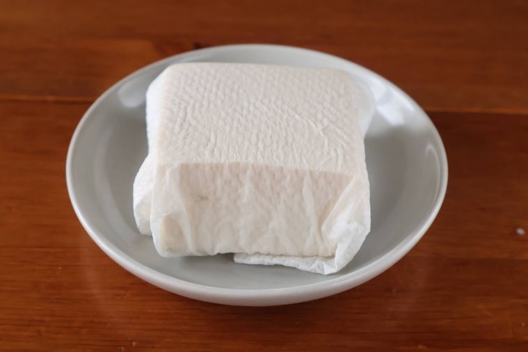 豆腐がキッチンペーペーに包まれている