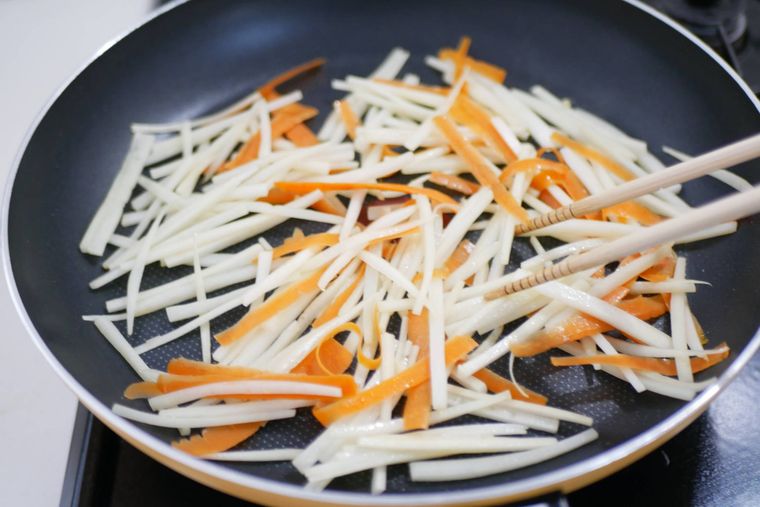 フライパンで大根の皮とにんじんの皮を炒めている様子