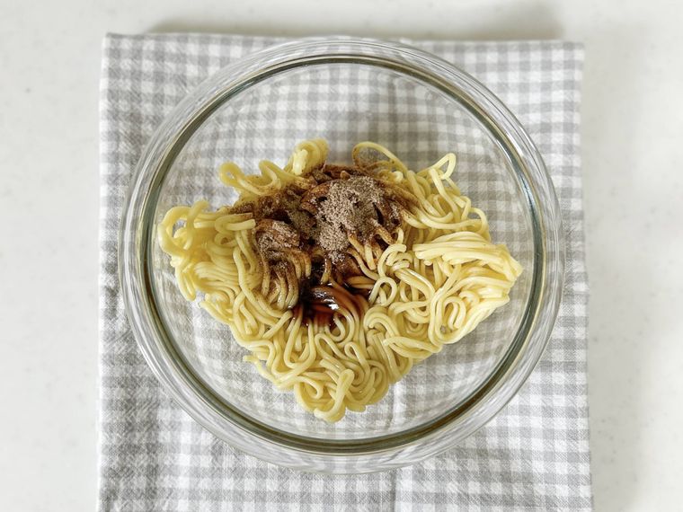 ガラスの耐熱ボウルに入った焼きそば、焼きそばの粉末ソース、オイスターソース、酒、ごま油