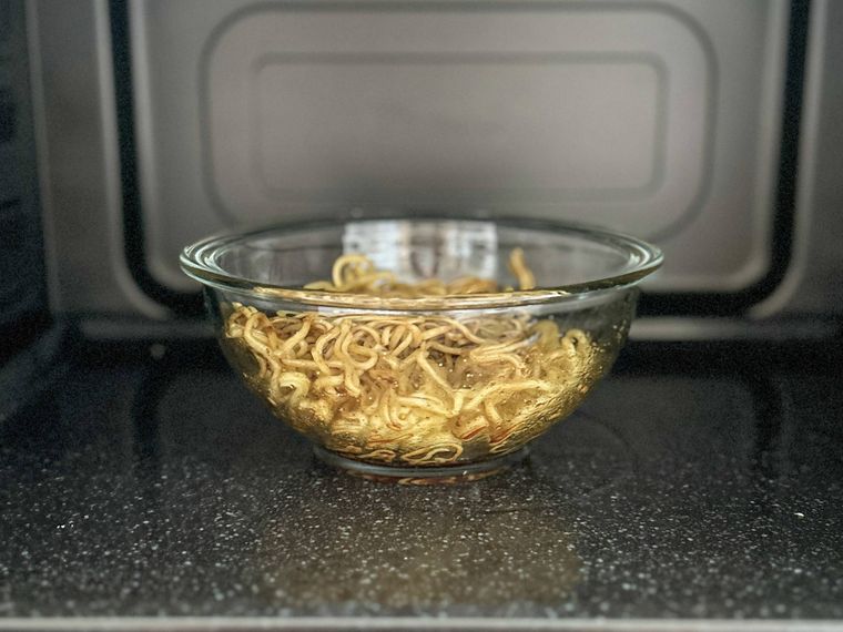 電子レンジに入れた焼きそば、焼きそばの粉末ソース、オイスターソース、酒、ごま油