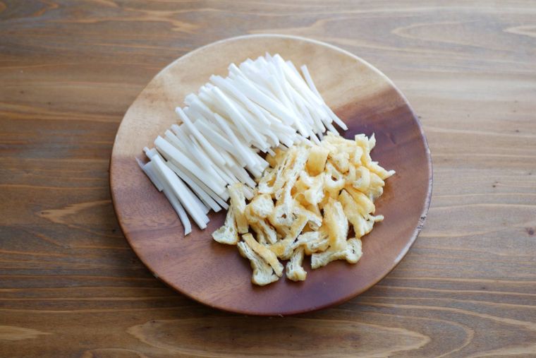 木製の皿に大根の皮と油揚げが盛られている