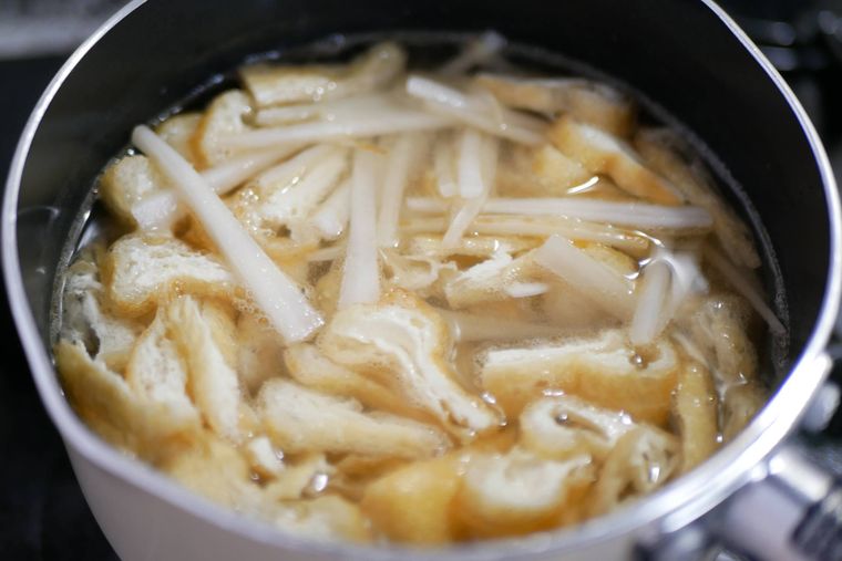 小鍋で大根の皮と油揚げを煮る様子