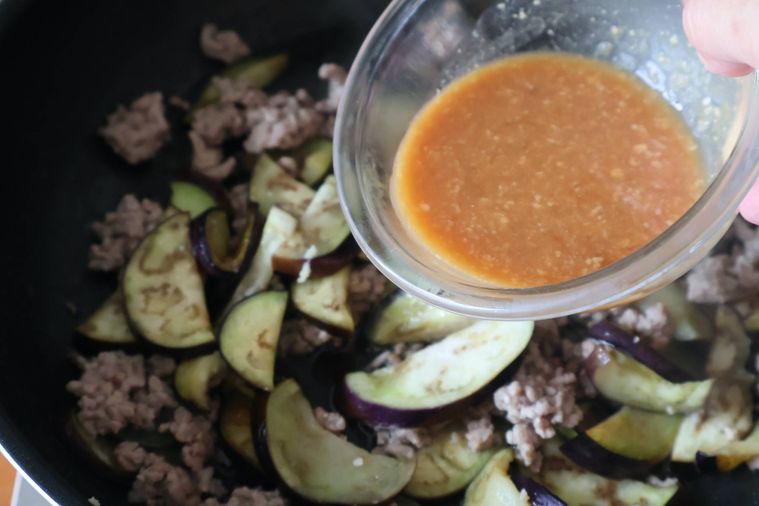 フライパンにみそだれを入れようとしている