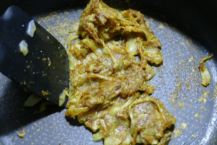 しょうがとにんにく、カレー粉を加えてヘラで練りながら炒める様子