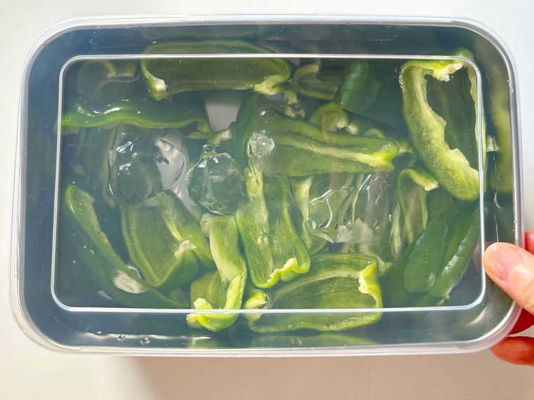 保存容器に氷水とピーマンを入れて蓋をしたもの