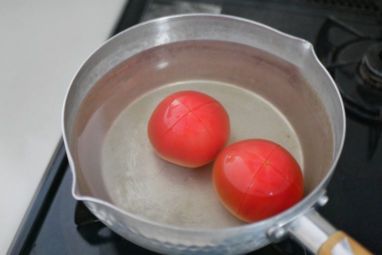 鍋にお湯とトマトが入っている様子