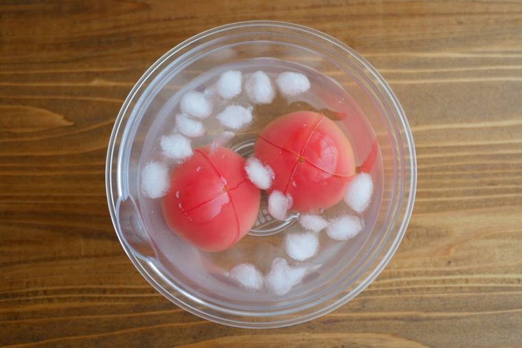 ボウルに入った氷水のなかでトマトを冷やす様子
