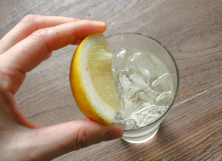 ハイボールにレモンを搾っている様子