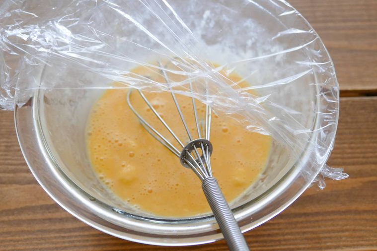 卵とマヨネーズをボウルに入れて泡だて器で混ぜる様子