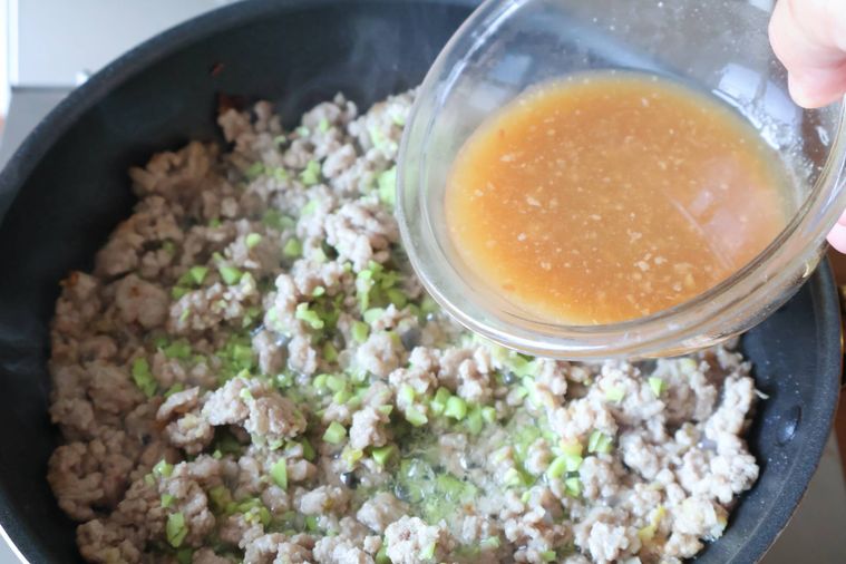 フライパンに合わせ調味料を加えている