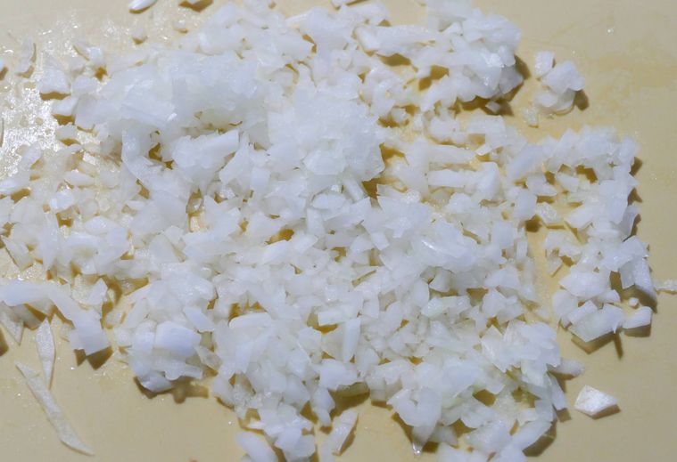 みじん切り玉ねぎがのっているまな板