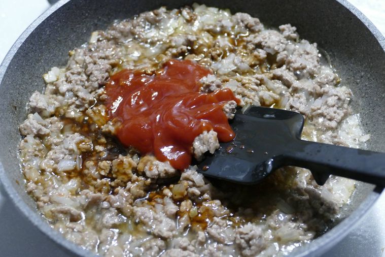 調味料を加えてヘラで混ぜる様子