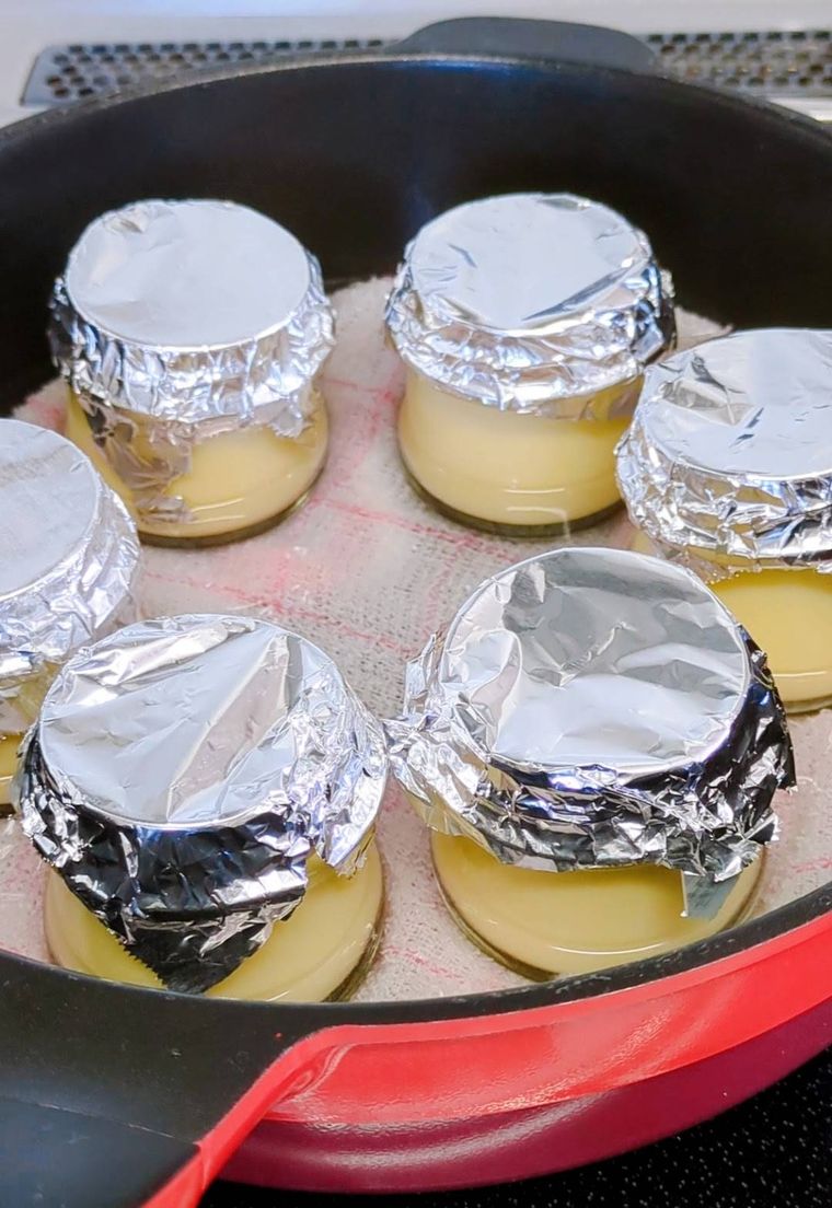 お湯と布巾と加熱前のプリンが入ったフライパン