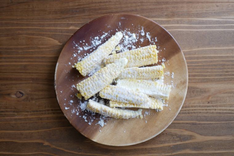 片栗粉をまぶしたとうもろこしが木製の皿の上に盛られている