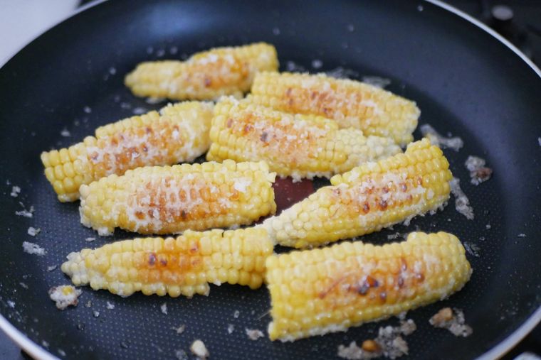 フライパンでとうもろこしを揚げ焼きにする様子
