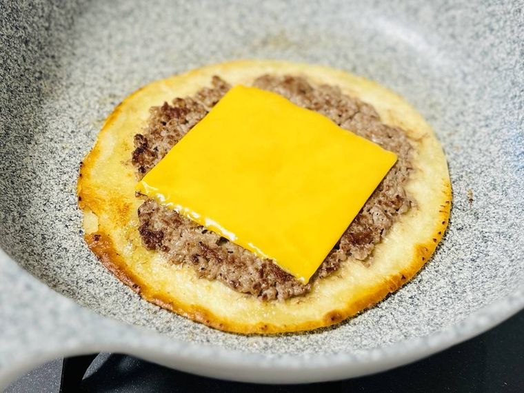 挽き肉とチェダーチーズがのったトルティーヤを焼いている様子