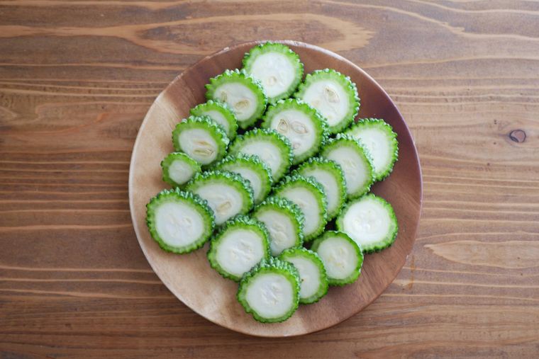 輪切りのゴーヤが木製の皿の上に並んでいる