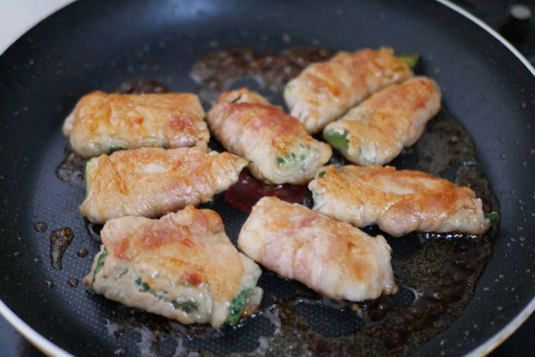 ゴーヤの肉巻きを焼き調味料を絡める様子