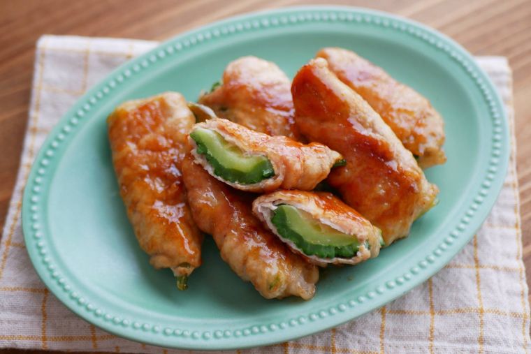緑色のオーバルプレートにゴーヤの肉巻きが盛られている