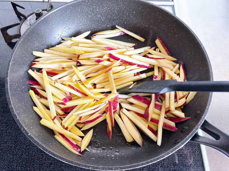 フライパンでさつまいもを炒める様子