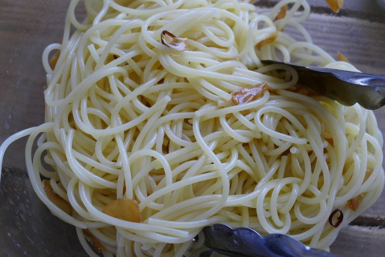 オイルとスパゲッティを和える様子