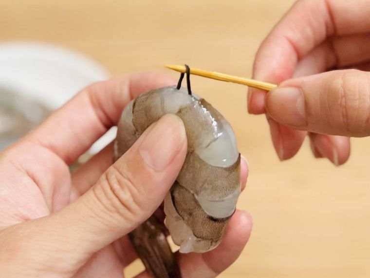 竹串でえびの背わたを取っている様子