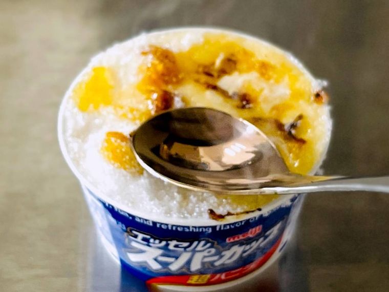 砂糖をかけたエッセル スーパーカップに熱したスプーンを当てている様子