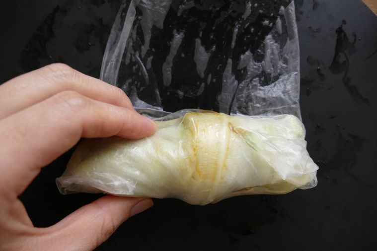 ライスペーパーで具材を包んだレタスを巻く様子