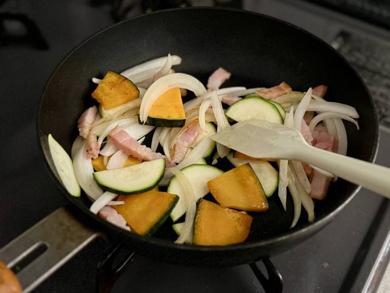 フライパンで野菜を炒めている様子