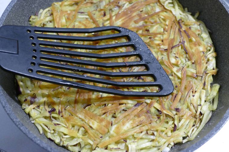 ガレットを返してフライ返しで押さえる様子