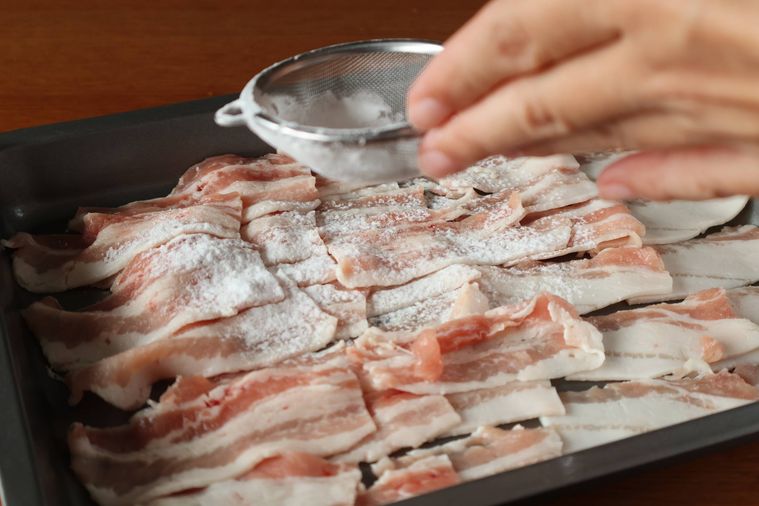 豚肉に片栗粉を振っている