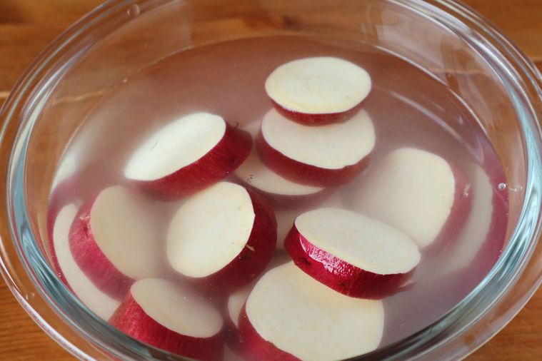 輪切りのさつまいもを水にさらしている