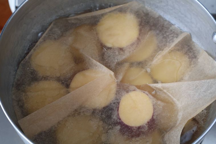 さつまいもに落しぶたをして煮ている