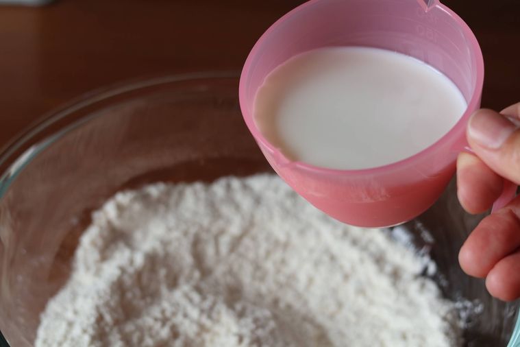 ボウルに牛乳を入れようとしている