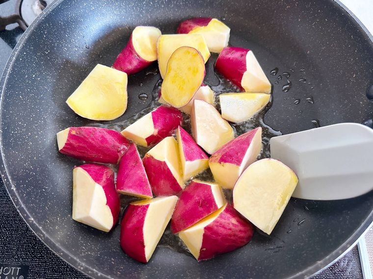 フライパンでさつまいもを炒める様子