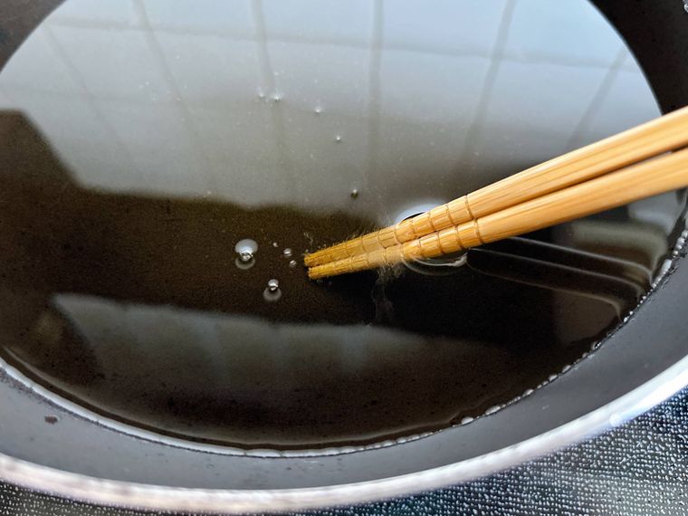 フライパンの油の中に菜箸を入れた様子