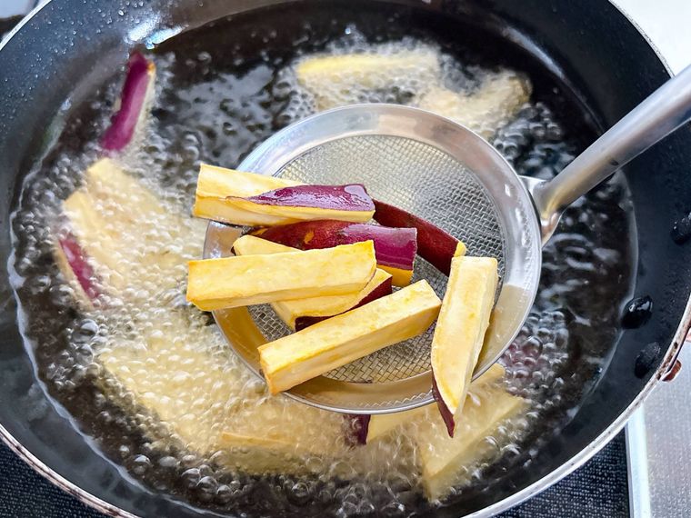 さつまいもを油から引き上げる様子