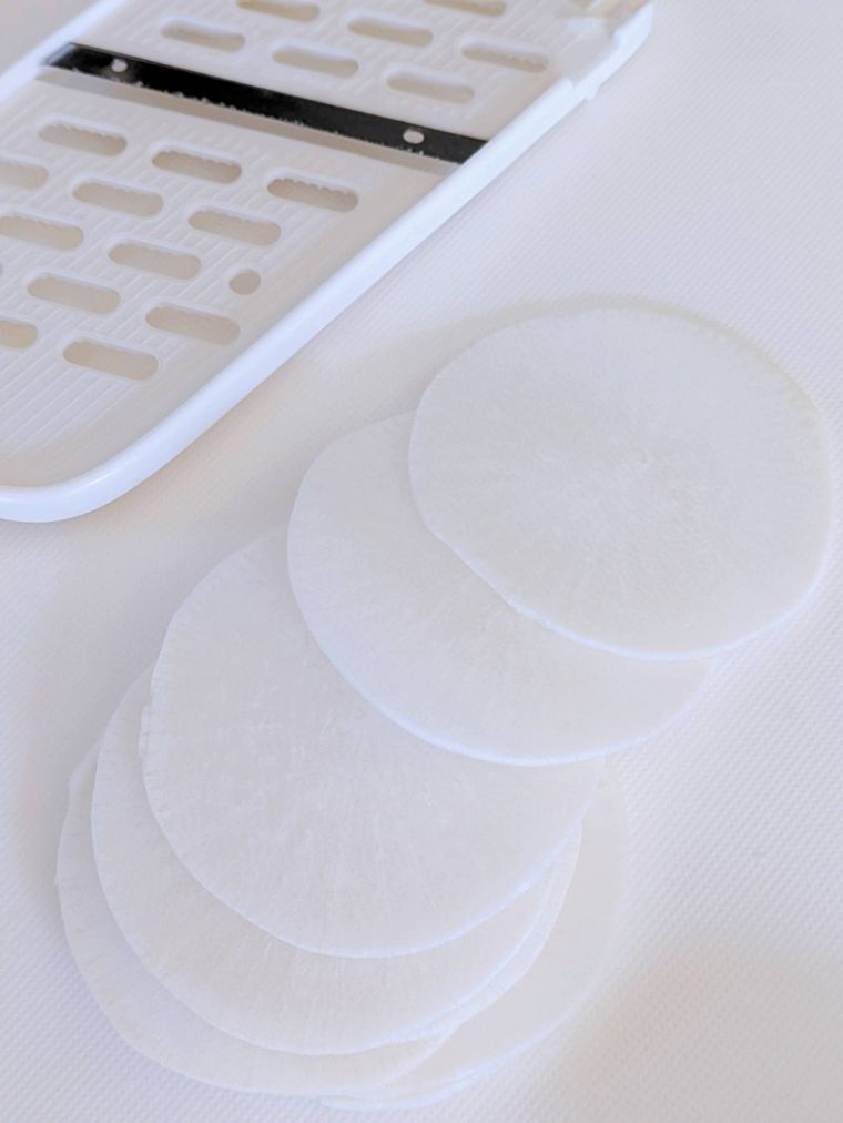 まな板の上のスライサーとスライスした大根