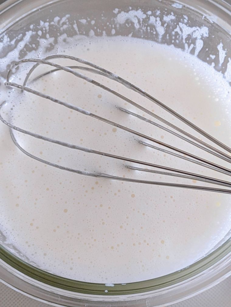 電子レンジ加熱後、耐熱ボウルの中のマシュマロと牛乳を泡立て器で混ぜた状態