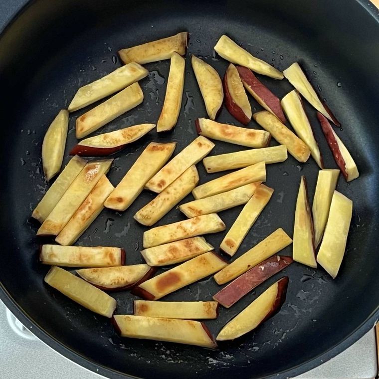 フライパンでさつまいもを炒めている様子