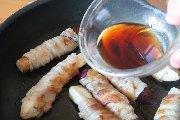 フライパンに調味料を加えている