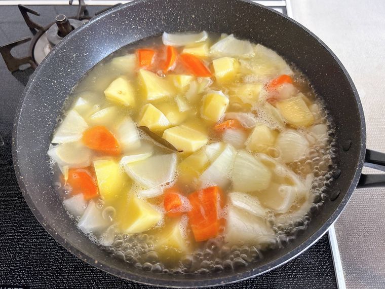 水とローリエ、コンソメを加えて煮る様子