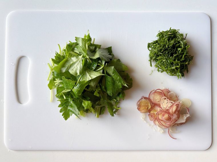まな板におかれたざく切りの三つ葉、千切りの大葉、薄切りのみょうが