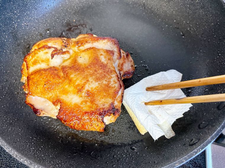 フライパンの油をキッチンペーパーで拭く様子